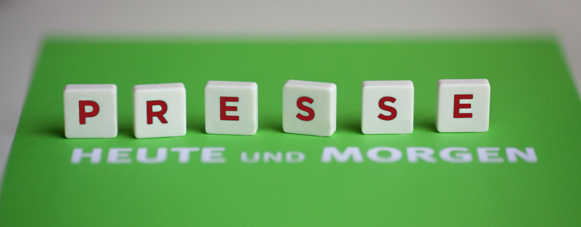 Bild von Scrabble-Teilen, auf denen "Presse" steht. Darunter ist eine grüne Karte, auf der "HEUTE UND MORGEN" steht