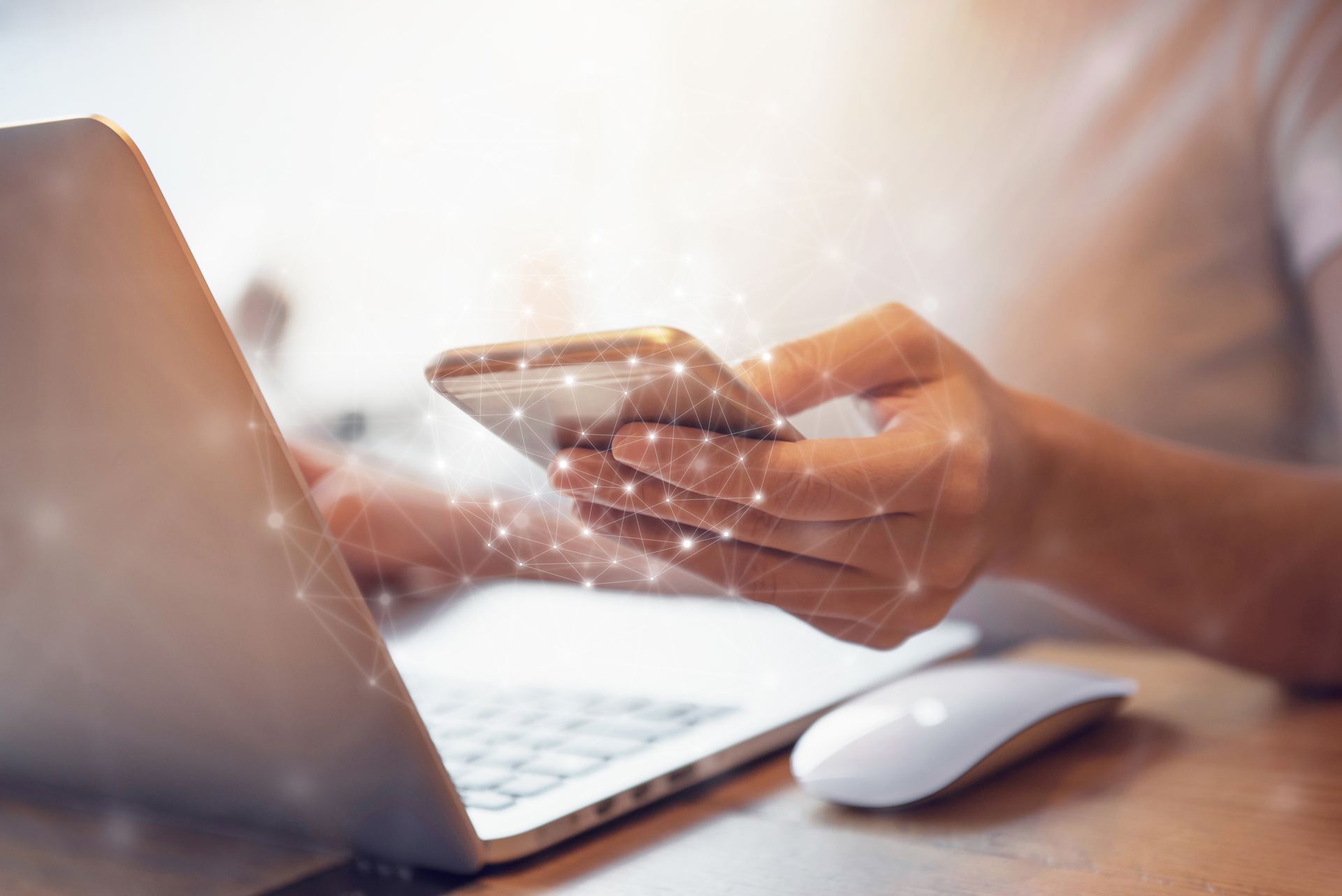 Techmonitor 2021 Person mit Handy in der Hand vor einem Laptop