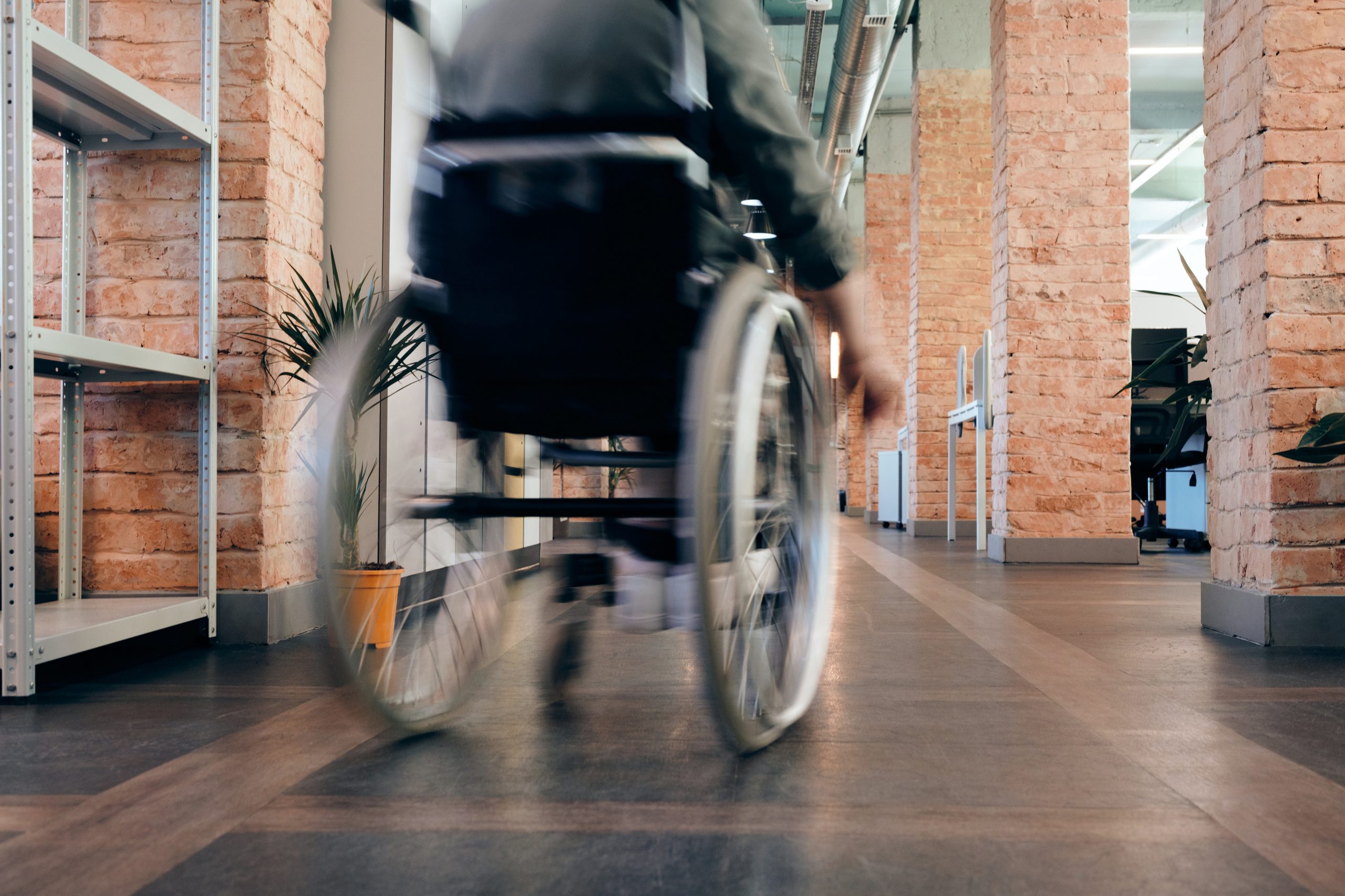 Customer Journey Berufsunfähigkeitsversicherung – Folgestudie 2022 – HEUTE UND MORGEN Bild eines Rollstuhlfahrers in einem Büro
